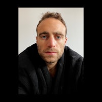 a man in a black robe is staring at the camera