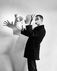 a black and white photo of a man with his hands in the air